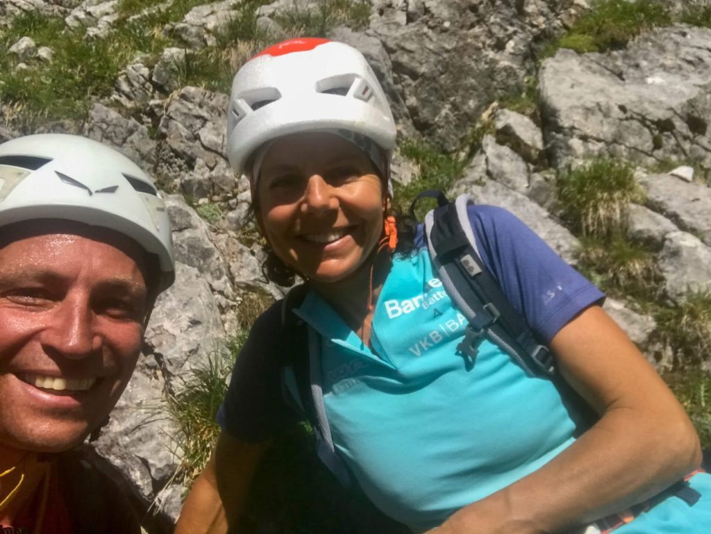 Zwei Kletterer mit Helmen und Rucksack lächeln im Felsgelände, Bergsport Outdoor-Aufnahme