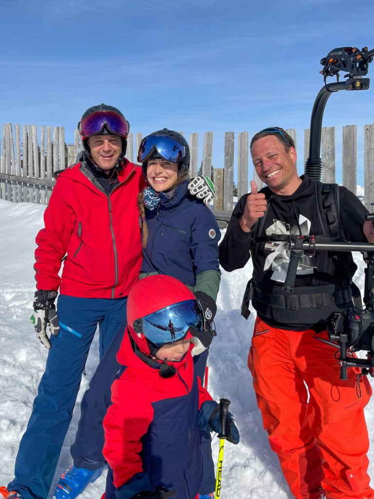 Skifahrer mit Kameramann und Gimbal im Schnee, professionelle Filmaufnahme am Skigebiet