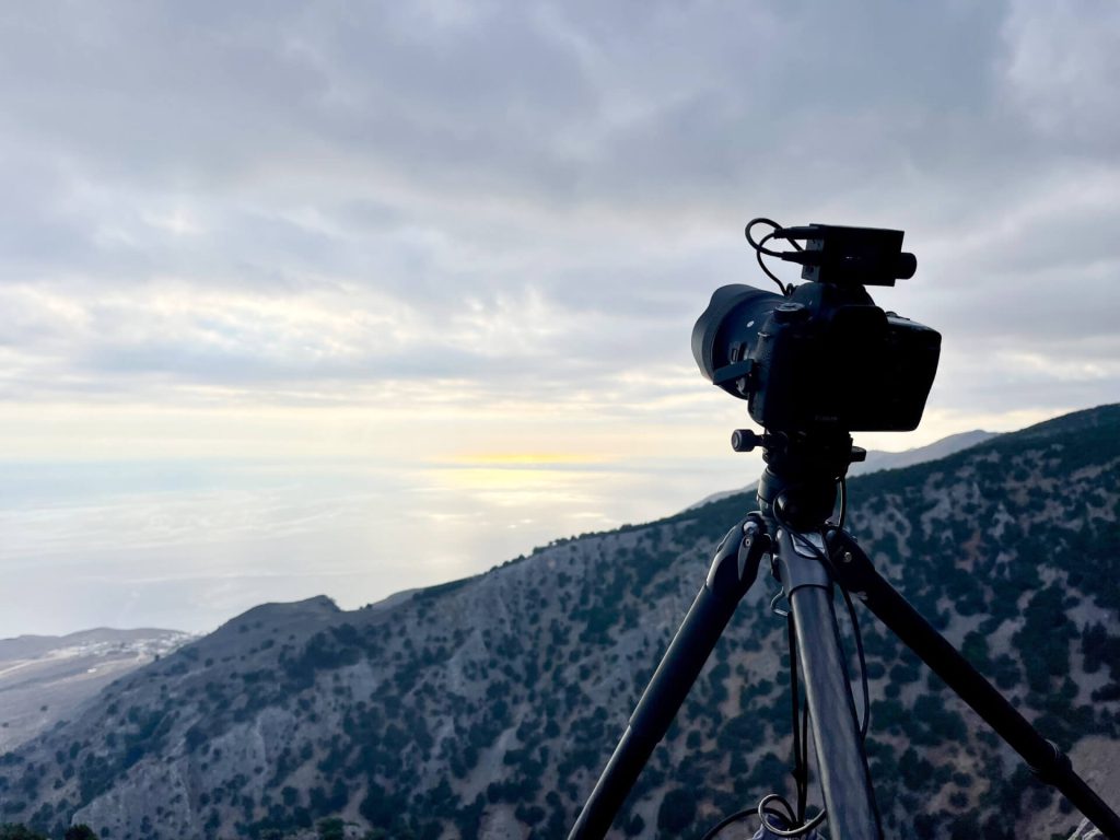 Kamera auf Stativ filmt Berglandschaft bei Sonnenuntergang, Timelapse und professionelle Videoproduktion