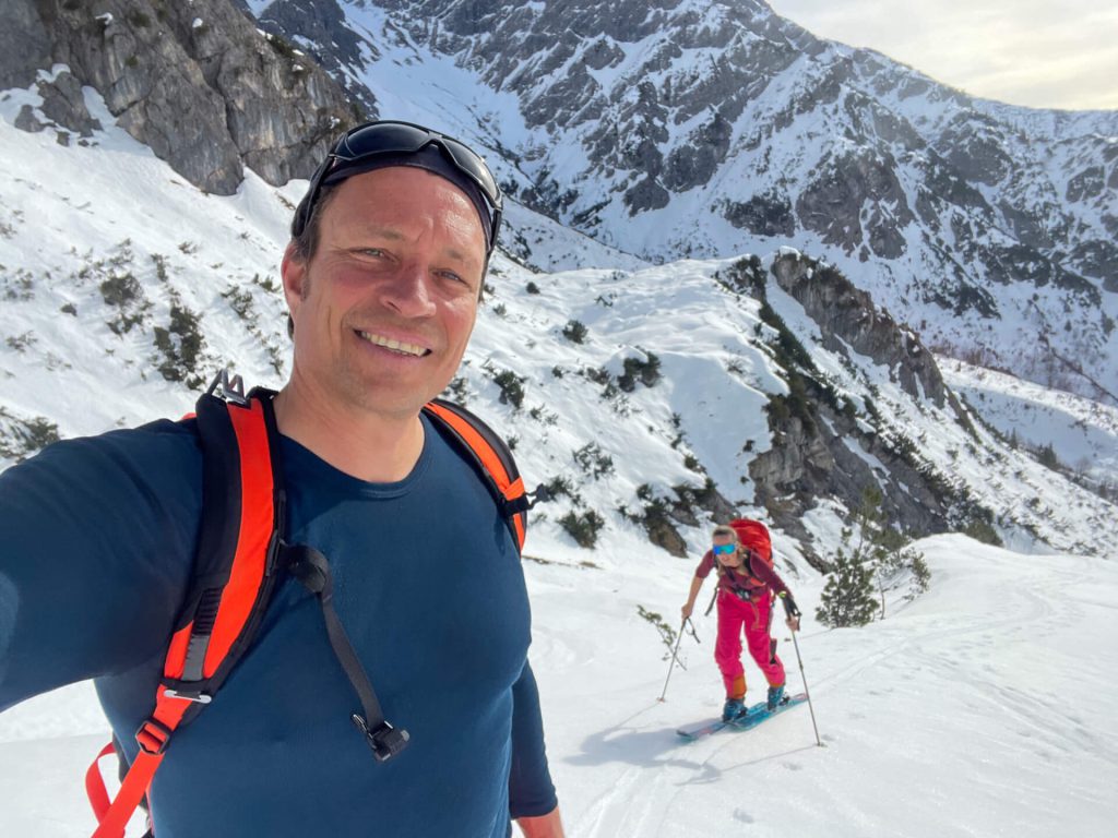 Zwei Skitourengeher bei Sonnenschein im verschneiten Gebirge, professionelle Outdooraufnahme